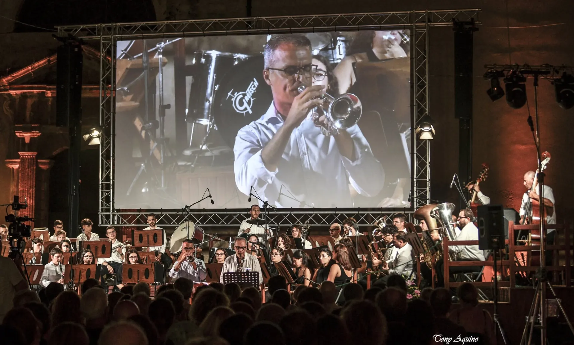 Orchestra in concerto con il primo piano del trombettista proiettato sul maxischermo